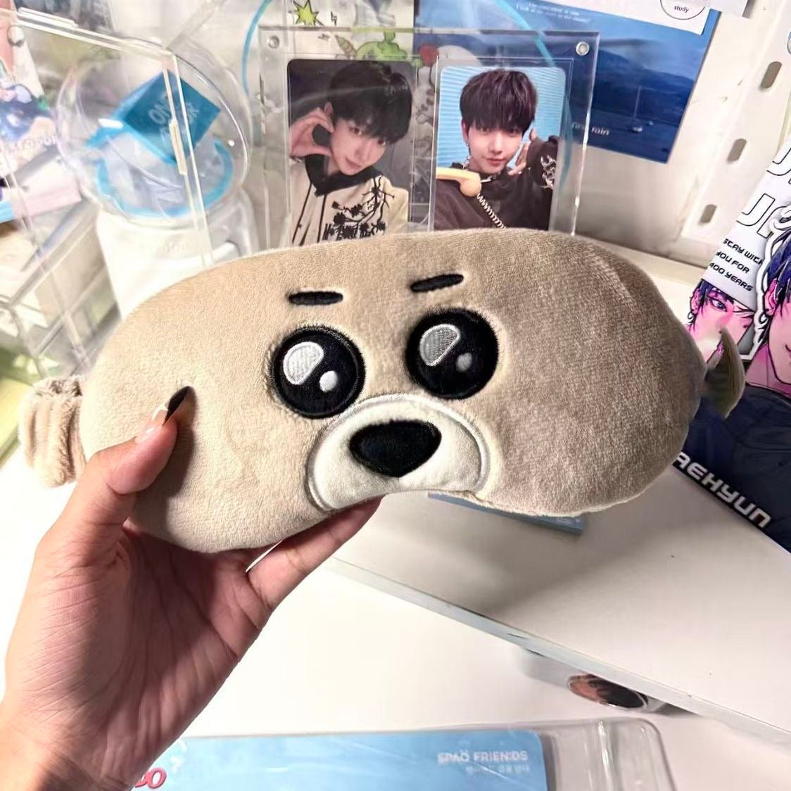 Beige dog character BOYNEXTDOOR eye mask held in a fan display setting